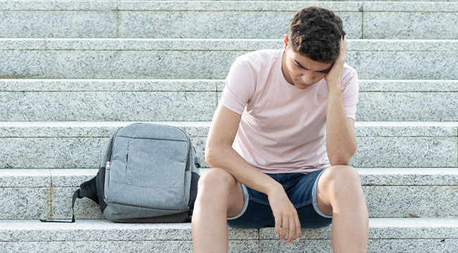 mental health: distressed student looking away from his computer